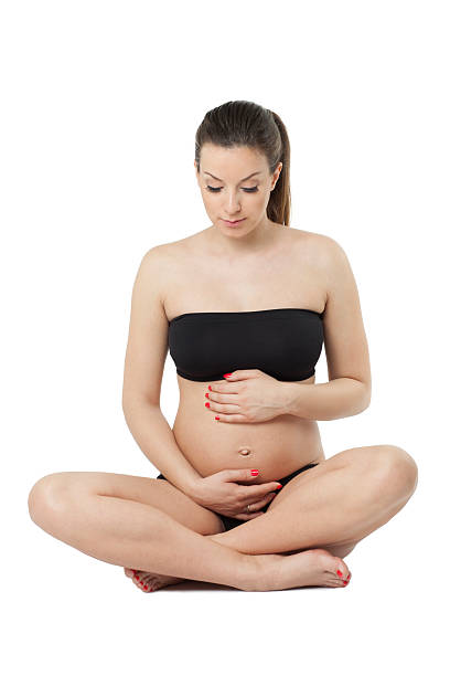 istock Woman holding her pregnant belly. White background. 477577323