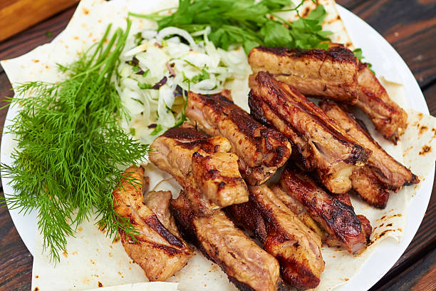istock grilled ribs on fire with vegetables 477579070