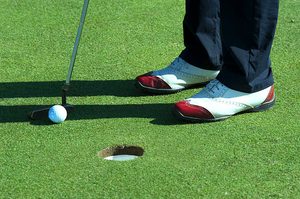 istock Golf putting and red shoes 477579884