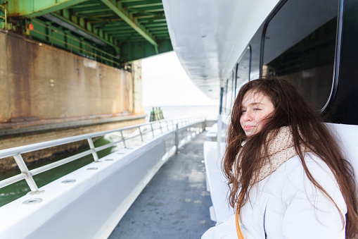 Long-haired teenager girl on the recreational yacht. The trip in Long Island, New York State, USA, around the Jones Beach.