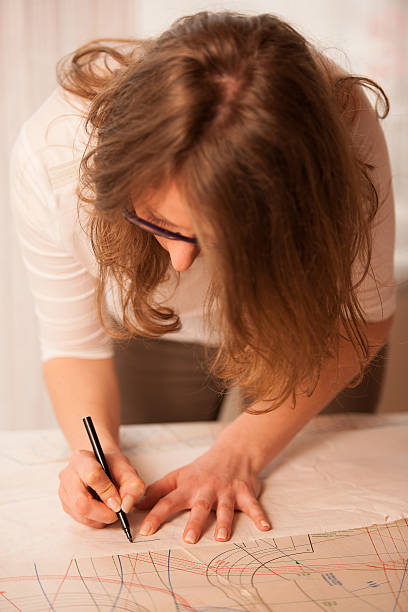 istock woman tailor copying pattern of dress in craft workshop 477585302