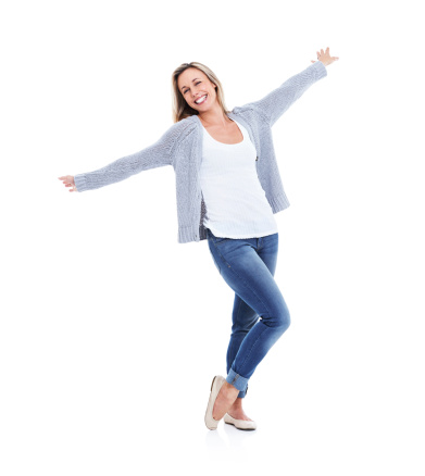 Studio shot of a smiling casual woman with her arms outstretched against a white background