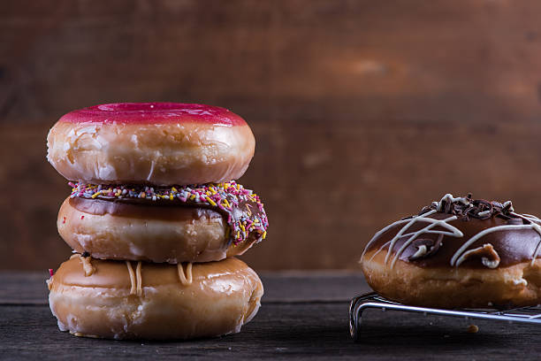 istock Stack of hand decorated artisan donut, wooden background 477587506