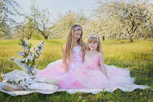 istock Two little sisters in pink dresses 477587716