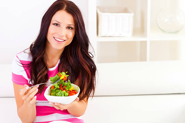 istock Young woman eating a salad 477589105