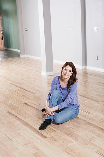 istock Woman sitting on wood floor 477589173