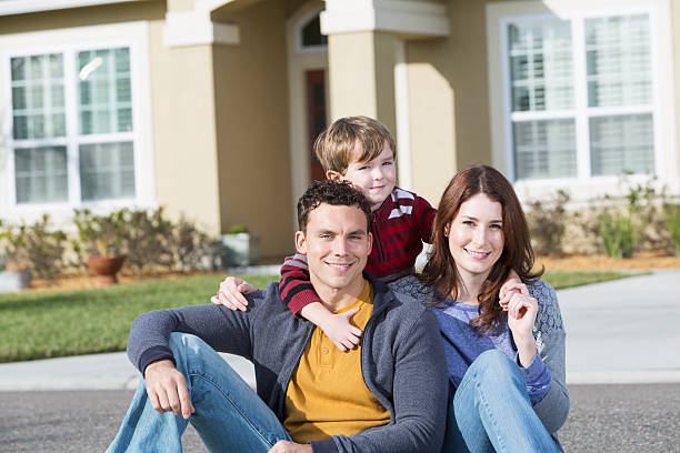 istock Young family in front of home 477589179