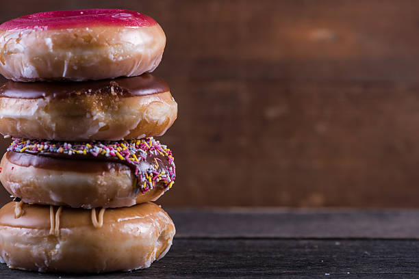 istock Stack of hand decorated artisan donut, wooden background 477591610