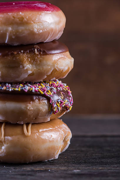 istock Stack of hand decorated artisan donut, wooden background 477591612