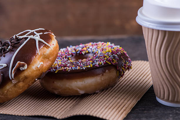 istock fresh artisan donuts and take away coffee, wooden background 477592254