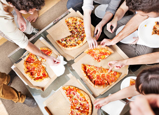 personas que toman porciones de pizza - pizza party fotografías e imágenes de stock