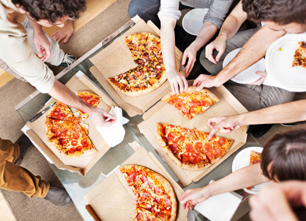 People taking pizza slices stock photo