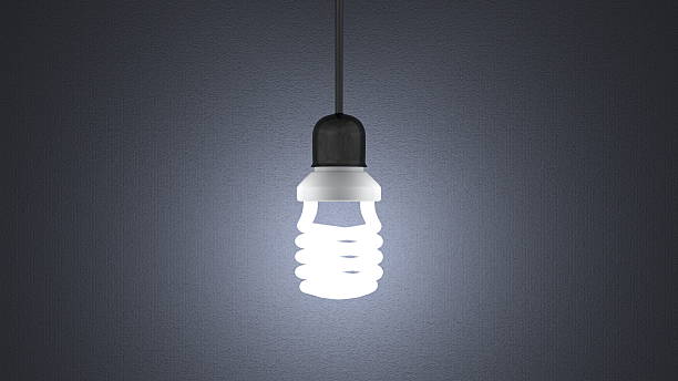 istock Glowing spiral light bulb hanging on gray 477594551