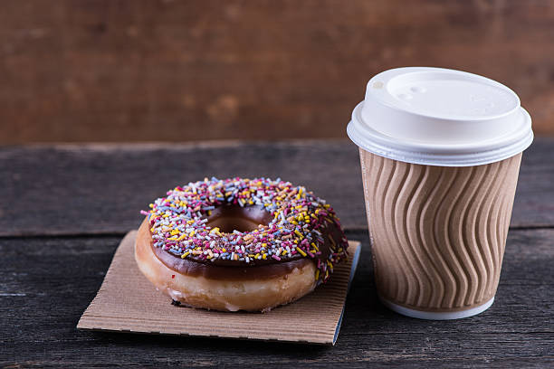 istock fresh artisan donut and take away coffee, wooden background 477595800
