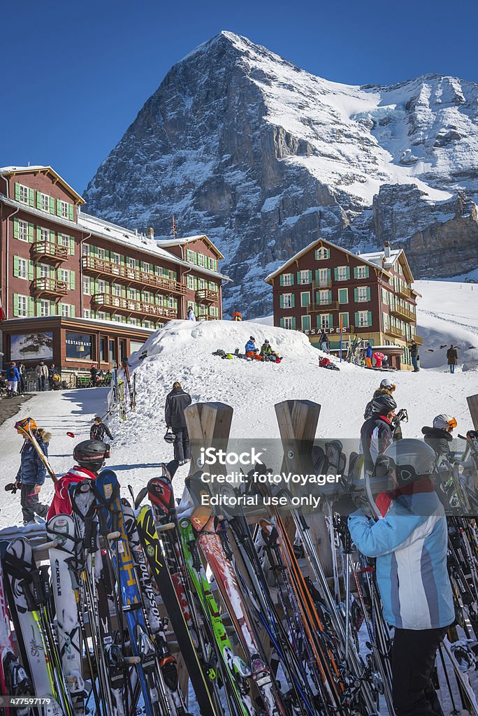 Skiers at Alpine winter sports resort Kleine Scheidegg Eiger Switzerland Kleine Scheidegg, Switzerland - 24th February 2014: The iconic North Face of the Eiger (3970m) overlooking the skiers and tourists enjoying the snow and sunshine at Kleine Scheidegg, the famous winter sports resort high in the Bernese Alps of Switzerland. Skiing Stock Photo