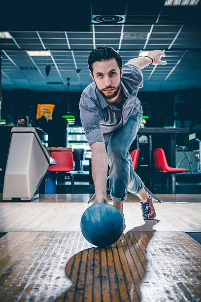 Man throwing bowling ball stock photo