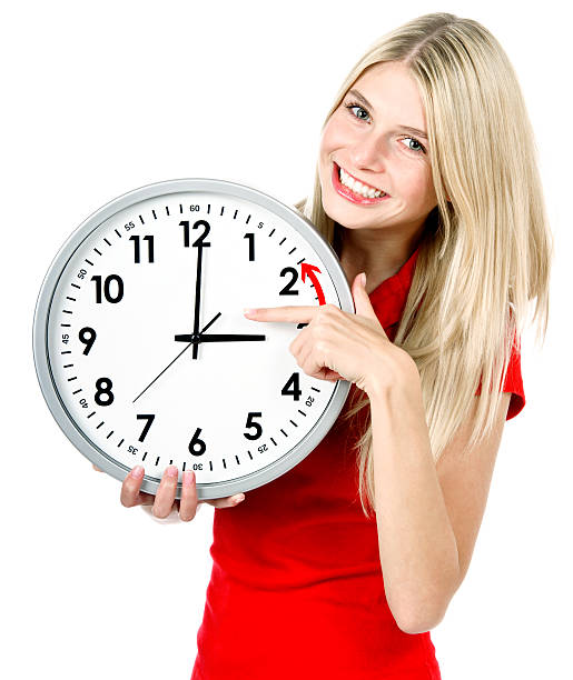 istock young woman holding a clock. winter time 477604761