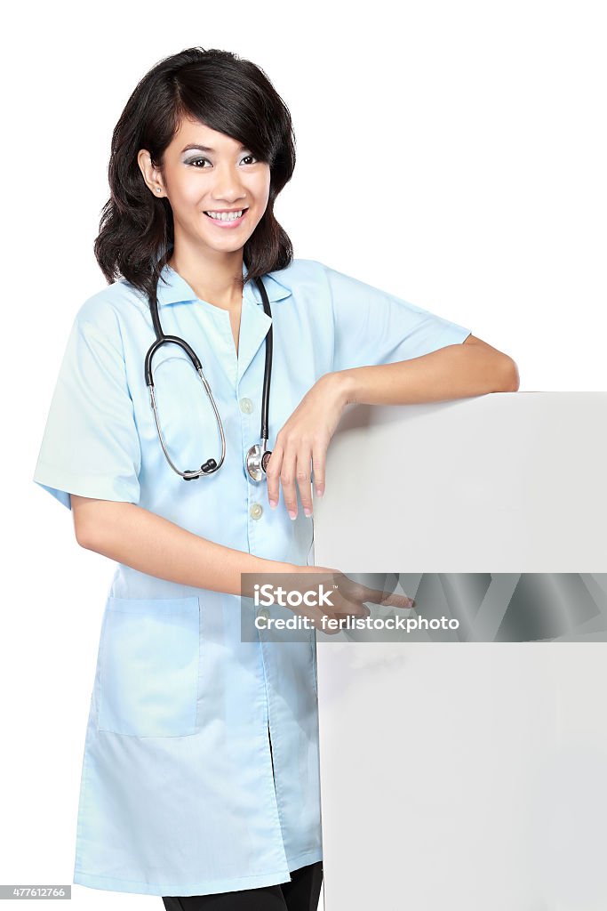 female doctor with a blankboard A smiling female doctor pointing a blankboard, isolated on white background 2015 Stock Photo