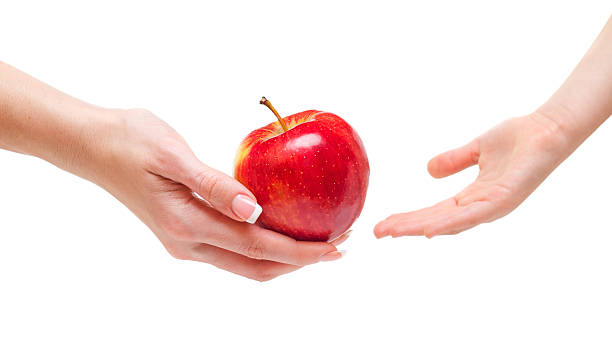 istock Woman giving apple to children 477612845