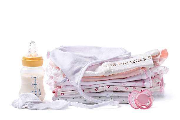 istock Folded clothes for babies with bottle of milk and pacifier 477613680