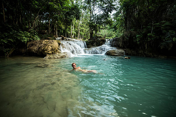 istock Woman enjoying bathing in waterfall 477614638