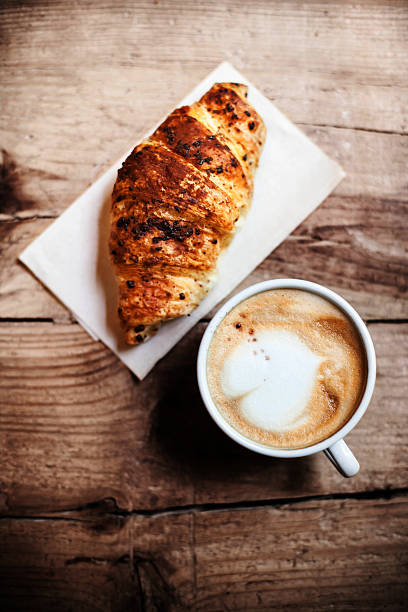 istock Coffee and fresh croissant for breakfast on rustic wooden table 477628084