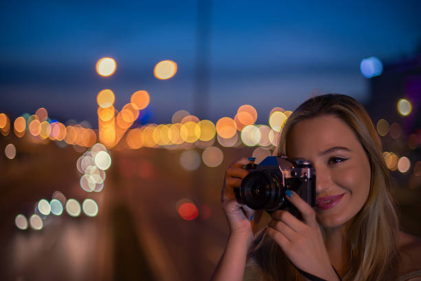 dziewczyna przy użyciu kamery o blond włosach vitage - camera retro revival old fashioned holding zdjęcia i obrazy z banku zdjęć