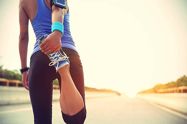 giovane donna corridore riscaldamento all'aperto - running jogging asian ethnicity women foto e immagini stock