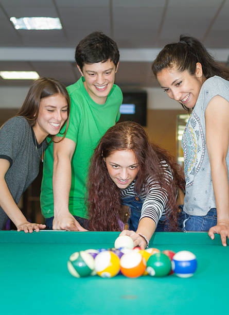 istock Young friends playing pool or billiard 477628220