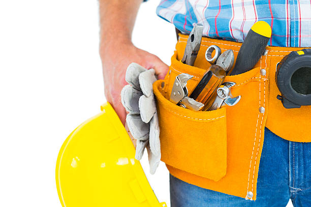trabajador manual uso de cinturón de herramientas mientras sostiene los guantes y casco - tool belt belt work tool pliers fotografías e imágenes de stock