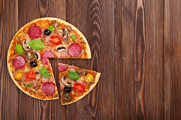 istock Italian pizza with pepperoni, tomatoes, olives and basil 477630506