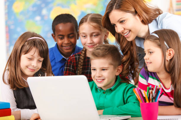 istock School children using laptop with teacher in the classroom 477633509