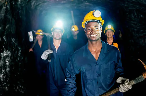 Group of miners in a mine looking happy