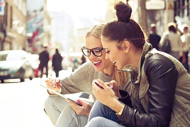 duas mulheres jovens com tablet na rua - women travel destinations london england tourist imagens e fotografias de stock