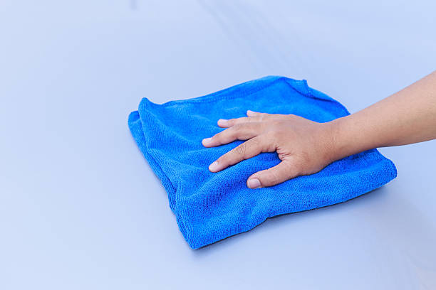 istock Woman hand with blue microfiber cloth cleaning the car 477634006
