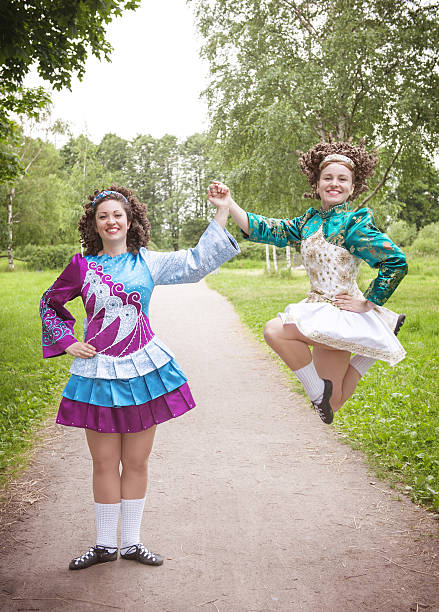 Two young beautiful girls in irish dance dress dancing outdoor stock photo