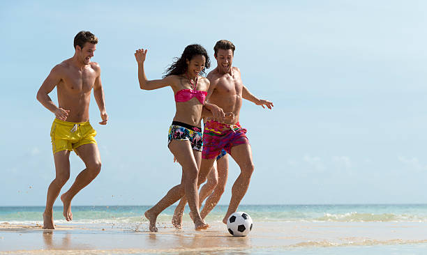 istock Young People Playing Football On The Beach 477634791