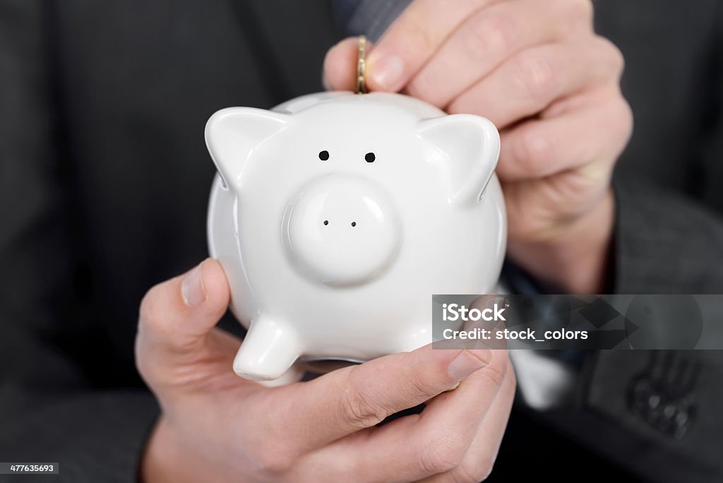businessman investing young businessman with coin bank putting money in it. Adult Stock Photo