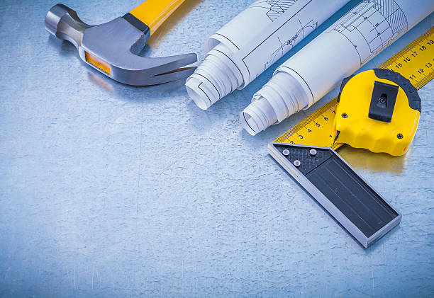 istock Construction drawings tape measure square ruler and claw hammer 477637366