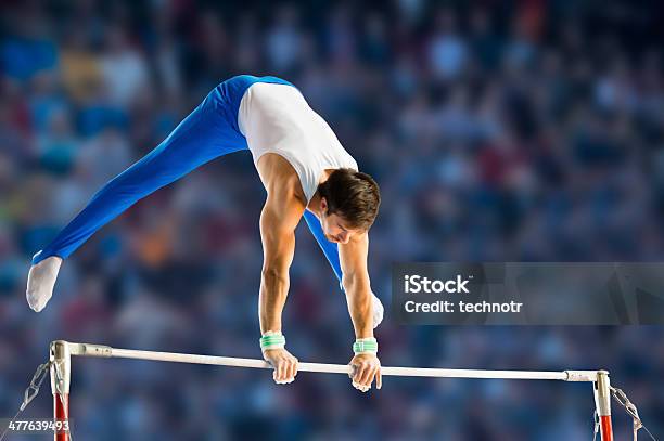 Male Gymnast Performing Routine On Horizontal Bar Stock Photo - Download Image Now - Gymnastics, Artistic Gymnastics, Horizontal Bar