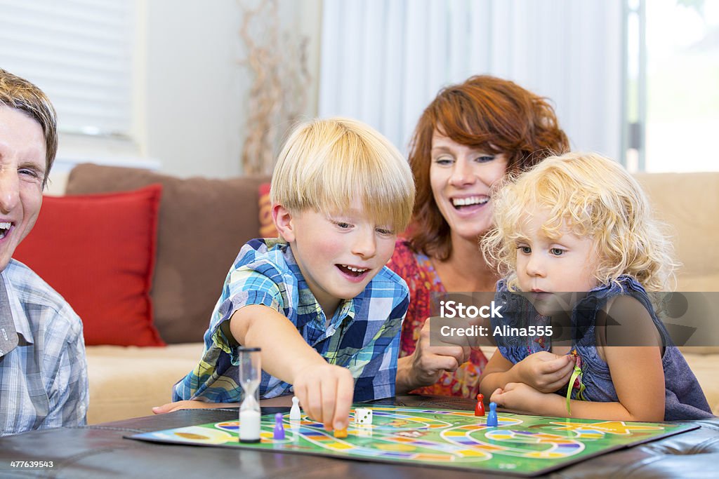 幸せな家族の 2 人の子供と遊ぶボードゲームをお楽しみください。 - ボードゲームのロイヤリティフリーストックフォト