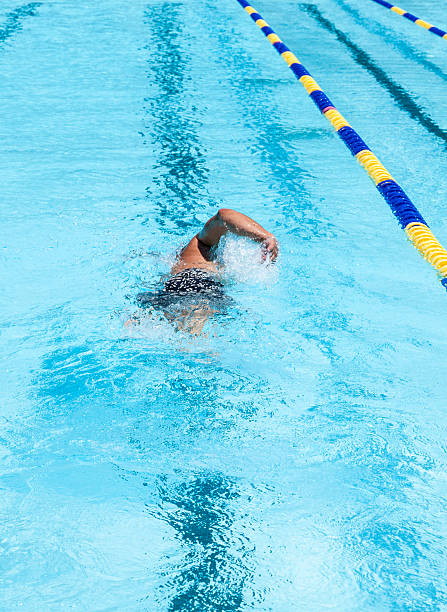 Swimming Laps Man swimming laps in community pool alone doing freestyle stroke. water athlete competitive sport vertical stock pictures, royalty-free photos & images