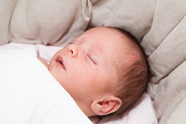 istock Newborn baby girl sleeping peacefully 477640198