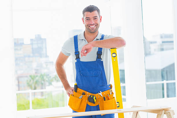 istock Carpenter in overalls with spirit level 477643834