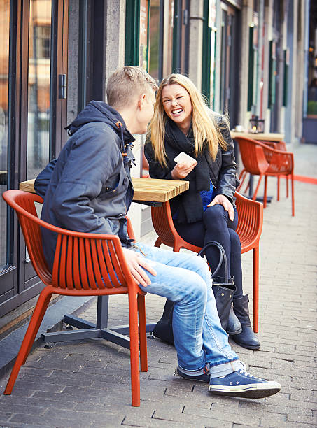 istock Young couple laughing at street cafe 477645089