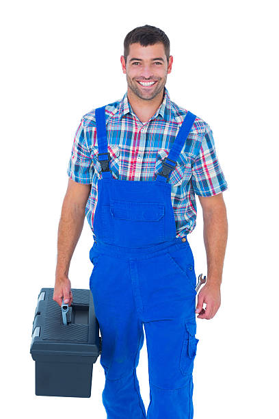 istock Happy handyman in coveralls carrying toolbox 477652104