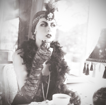 Black and White Portrait of The Beautiful Retro woman Sitting in the Cafe in Black Lace and Accessories  in Style 1920s - 1930s 