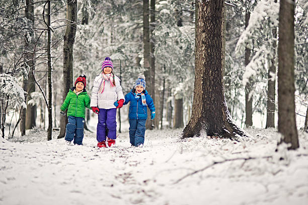 istock Kids walking in winter forest 477653023