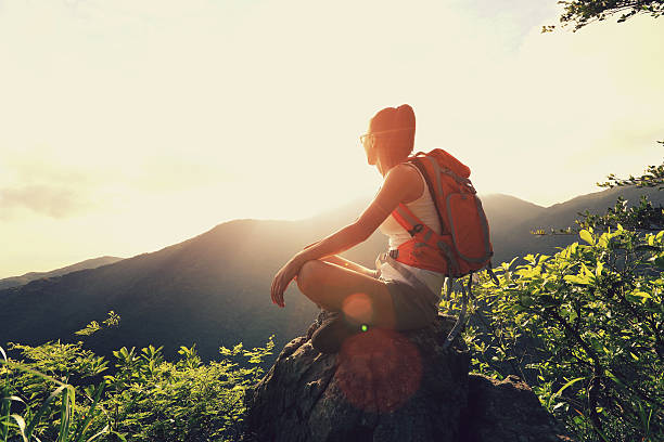 istock woman backpacker enjoy the view at mountain peak cliff 477655696