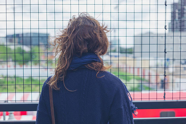 istock Young woman by wire fence 477656844
